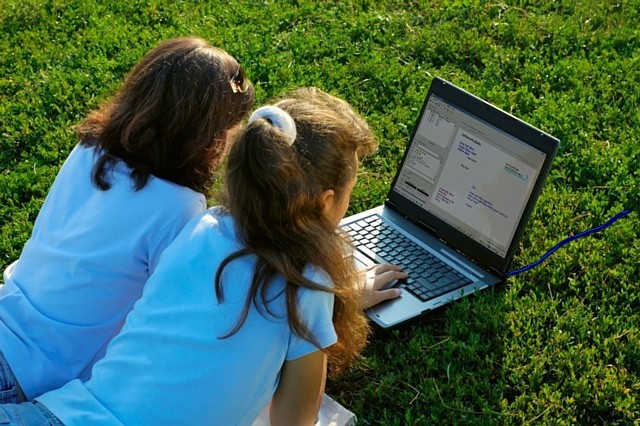 Girls looking at a laptop with the Briteschool classroom on the screen.  Copyright AlexMax, fotolia.co.uk
